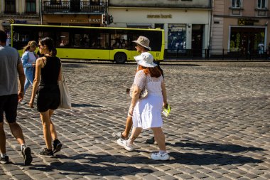 Lviv, Ukrayna, 18 Ağustos 2024 Lviv sakinleri ve turistler tarihi şehir merkezinde yürüyorlar. Ülke savaşta olmasına rağmen, çoğu işletme açık ve insanlar normal bir hayat yaşamaya çalışıyor..