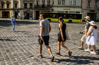 Lviv, Ukrayna, 18 Ağustos 2024 Lviv sakinleri ve turistler tarihi şehir merkezinde yürüyorlar. Ülke savaşta olmasına rağmen, çoğu işletme açık ve insanlar normal bir hayat yaşamaya çalışıyor..