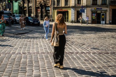 Lviv, Ukrayna, 18 Ağustos 2024 Lviv sakinleri ve turistler tarihi şehir merkezinde yürüyorlar. Ülke savaşta olmasına rağmen, çoğu işletme açık ve insanlar normal bir hayat yaşamaya çalışıyor..
