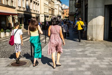 Lviv, Ukrayna, 18 Ağustos 2024 Lviv sakinleri ve turistler tarihi şehir merkezinde yürüyorlar. Ülke savaşta olmasına rağmen, çoğu işletme açık ve insanlar normal bir hayat yaşamaya çalışıyor..
