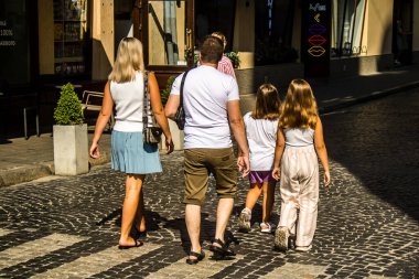 Lviv, Ukrayna, 18 Ağustos 2024 Lviv sakinleri ve turistler tarihi şehir merkezinde yürüyorlar. Ülke savaşta olmasına rağmen, çoğu işletme açık ve insanlar normal bir hayat yaşamaya çalışıyor..