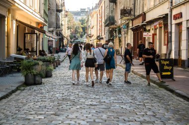 Lviv, Ukrayna, 18 Ağustos 2024 Lviv sakinleri ve turistler tarihi şehir merkezinde yürüyorlar. Ülke savaşta olmasına rağmen, çoğu işletme açık ve insanlar normal bir hayat yaşamaya çalışıyor..
