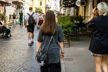 Lviv, Ukrayna, 18 Ağustos 2024 Lviv sakinleri ve turistler tarihi şehir merkezinde yürüyorlar. Ülke savaşta olmasına rağmen, çoğu işletme açık ve insanlar normal bir hayat yaşamaya çalışıyor..