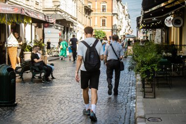 Lviv, Ukrayna, 18 Ağustos 2024 Lviv sakinleri ve turistler tarihi şehir merkezinde yürüyorlar. Ülke savaşta olmasına rağmen, çoğu işletme açık ve insanlar normal bir hayat yaşamaya çalışıyor..