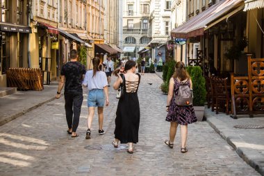 Lviv, Ukrayna, 18 Ağustos 2024 Lviv sakinleri ve turistler tarihi şehir merkezinde yürüyorlar. Ülke savaşta olmasına rağmen, çoğu işletme açık ve insanlar normal bir hayat yaşamaya çalışıyor..