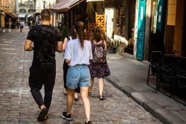 Lviv, Ukrayna, 18 Ağustos 2024 Lviv sakinleri ve turistler tarihi şehir merkezinde yürüyorlar. Ülke savaşta olmasına rağmen, çoğu işletme açık ve insanlar normal bir hayat yaşamaya çalışıyor..