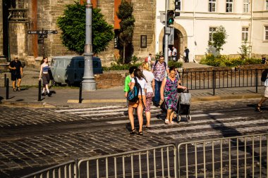 Lviv, Ukrayna, 18 Ağustos 2024 Lviv sakinleri ve turistler tarihi şehir merkezinde yürüyorlar. Ülke savaşta olmasına rağmen, çoğu işletme açık ve insanlar normal bir hayat yaşamaya çalışıyor..
