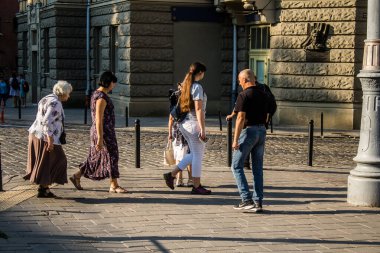 Lviv, Ukrayna, 18 Ağustos 2024 Lviv sakinleri ve turistler tarihi şehir merkezinde yürüyorlar. Ülke savaşta olmasına rağmen, çoğu işletme açık ve insanlar normal bir hayat yaşamaya çalışıyor..