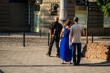 Lviv, Ukrayna, 18 Ağustos 2024 Lviv sakinleri ve turistler tarihi şehir merkezinde yürüyorlar. Ülke savaşta olmasına rağmen, çoğu işletme açık ve insanlar normal bir hayat yaşamaya çalışıyor..