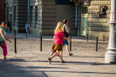 Lviv, Ukrayna, 18 Ağustos 2024 Lviv sakinleri ve turistler tarihi şehir merkezinde yürüyorlar. Ülke savaşta olmasına rağmen, çoğu işletme açık ve insanlar normal bir hayat yaşamaya çalışıyor..