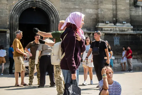 Lviv, Ukrayna, 18 Ağustos 2024 Lviv sakinleri ve turistler tarihi şehir merkezinde yürüyorlar. Ülke savaşta olmasına rağmen, çoğu işletme açık ve insanlar normal bir hayat yaşamaya çalışıyor..