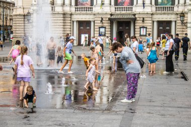 Lviv, Ukrayna, 22 Ağustos 2024 Çocuklar Lviv şehir merkezinde suyla oynuyorlar. Rusya 'yla savaş sırasında, Lviv binaları Rus füzeleri tarafından tehdit ediliyor ve hedef alınıyordu..