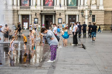 Lviv, Ukrayna, 22 Ağustos 2024 Çocuklar Lviv şehir merkezinde suyla oynuyorlar. Rusya 'yla savaş sırasında, Lviv binaları Rus füzeleri tarafından tehdit ediliyor ve hedef alınıyordu..