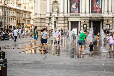 Lviv, Ukrayna, 22 Ağustos 2024 Çocuklar Lviv şehir merkezinde suyla oynuyorlar. Rusya 'yla savaş sırasında, Lviv binaları Rus füzeleri tarafından tehdit ediliyor ve hedef alınıyordu..