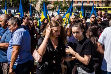 Lviv, Ukrayna, 23 Ağustos 2024. Lviv askeri mezarlığında Rus ordusuyla birlikte ölen üç Ukraynalı askerin cenazesine aile ve arkadaşlar katıldı..