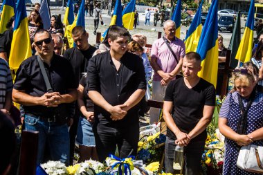 Lviv, Ukrayna, 23 Ağustos 2024. Lviv askeri mezarlığında Rus ordusuyla birlikte ölen üç Ukraynalı askerin cenazesine aile ve arkadaşlar katıldı..