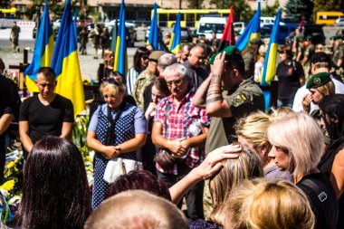 Lviv, Ukrayna, 23 Ağustos 2024. Lviv askeri mezarlığında Rus ordusuyla birlikte ölen üç Ukraynalı askerin cenazesine aile ve arkadaşlar katıldı..
