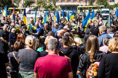 Lviv, Ukrayna, 23 Ağustos 2024. Lviv askeri mezarlığında Rus ordusuyla birlikte ölen üç Ukraynalı askerin cenazesine aile ve arkadaşlar katıldı..