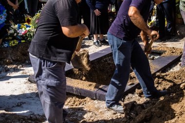 Lviv, Ukrayna, 23 Ağustos 2024. Lviv askeri mezarlığında Rus ordusuyla birlikte ölen üç Ukraynalı askerin cenazesine aile ve arkadaşlar katıldı..