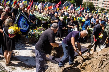 Lviv, Ukrayna, 23 Ağustos 2024. Lviv askeri mezarlığında Rus ordusuyla birlikte ölen üç Ukraynalı askerin cenazesine aile ve arkadaşlar katıldı..