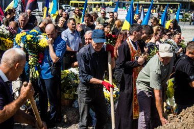 Lviv, Ukrayna, 23 Ağustos 2024. Lviv askeri mezarlığında Rus ordusuyla birlikte ölen üç Ukraynalı askerin cenazesine aile ve arkadaşlar katıldı..