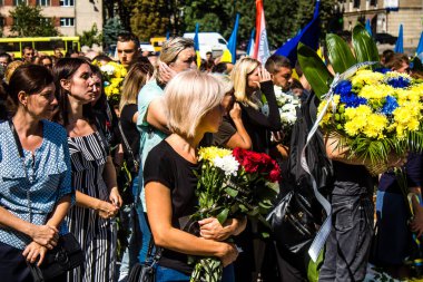 Lviv, Ukrayna, 23 Ağustos 2024. Lviv askeri mezarlığında Rus ordusuyla birlikte ölen üç Ukraynalı askerin cenazesine aile ve arkadaşlar katıldı..