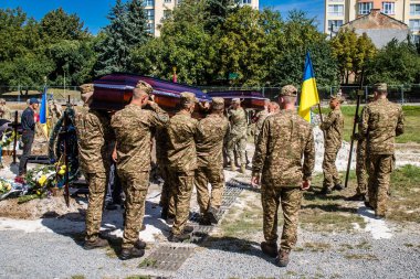 Lviv, Ukrayna, 23 Ağustos 2024. Lviv askeri mezarlığında Rus ordusuyla birlikte ölen üç Ukraynalı askerin cenazesine aile ve arkadaşlar katıldı..