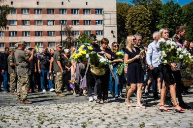 Lviv, Ukrayna, 23 Ağustos 2024. Lviv askeri mezarlığında Rus ordusuyla birlikte ölen üç Ukraynalı askerin cenazesine aile ve arkadaşlar katıldı..