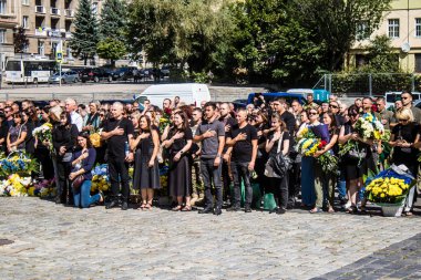 Lviv, Ukrayna, 23 Ağustos 2024. Lviv askeri mezarlığında Rus ordusuyla birlikte ölen üç Ukraynalı askerin cenazesine aile ve arkadaşlar katıldı..