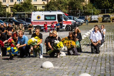 Lviv, Ukrayna, 23 Ağustos 2024. Lviv askeri mezarlığında Rus ordusuyla birlikte ölen üç Ukraynalı askerin cenazesine aile ve arkadaşlar katıldı..