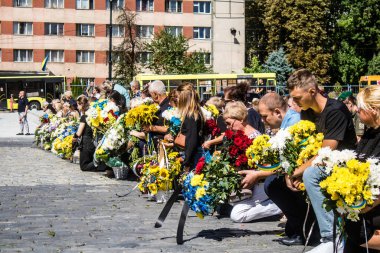 Lviv, Ukrayna, 23 Ağustos 2024. Lviv askeri mezarlığında Rus ordusuyla birlikte ölen üç Ukraynalı askerin cenazesine aile ve arkadaşlar katıldı..