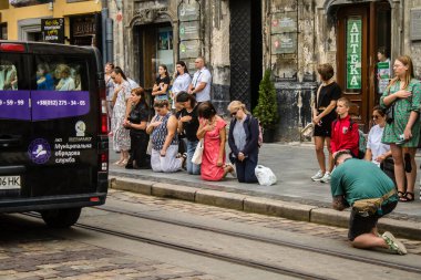 Lviv, Ukrayna, 27 Ağustos 2024. Lviv halkı, işgal altındaki Rus ordusuna karşı Lviv mezarlığına yapılan savaşta ölen üç Ukraynalı askerin konvoyu olarak yas tutuyor..