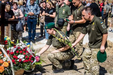 Lviv, Ukrayna, 29 Ağustos 2024 Mars meydanında, bir askeri mezarlık, askerler, silah arkadaşları, Rus ordusuna karşı savaşta ölen kendilerinden birinin mezarının önünde toplandı..