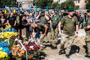 Lviv, Ukrayna, 29 Ağustos 2024 Mars meydanında, bir askeri mezarlık, askerler, silah arkadaşları, Rus ordusuna karşı savaşta ölen kendilerinden birinin mezarının önünde toplandı..
