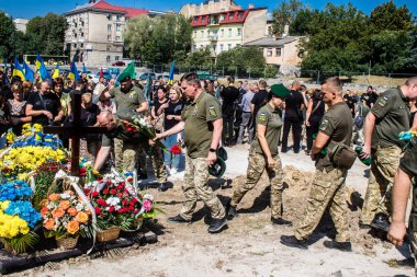 Lviv, Ukrayna, 29 Ağustos 2024 Mars meydanında, bir askeri mezarlık, askerler, silah arkadaşları, Rus ordusuna karşı savaşta ölen kendilerinden birinin mezarının önünde toplandı..