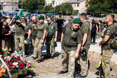 Lviv, Ukrayna, 29 Ağustos 2024 Mars meydanında, bir askeri mezarlık, askerler, silah arkadaşları, Rus ordusuna karşı savaşta ölen kendilerinden birinin mezarının önünde toplandı..