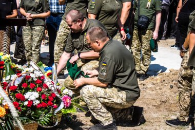 Lviv, Ukrayna, 29 Ağustos 2024 Mars meydanında, bir askeri mezarlık, askerler, silah arkadaşları, Rus ordusuna karşı savaşta ölen kendilerinden birinin mezarının önünde toplandı..
