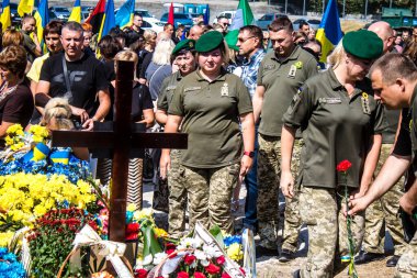 Lviv, Ukrayna, 29 Ağustos 2024 Mars meydanında, bir askeri mezarlık, askerler, silah arkadaşları, Rus ordusuna karşı savaşta ölen kendilerinden birinin mezarının önünde toplandı..