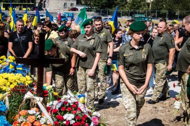 Lviv, Ukrayna, 29 Ağustos 2024 Mars meydanında, bir askeri mezarlık, askerler, silah arkadaşları, Rus ordusuna karşı savaşta ölen kendilerinden birinin mezarının önünde toplandı..