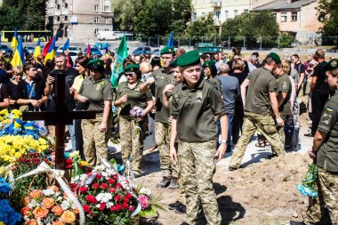 Lviv, Ukrayna, 29 Ağustos 2024 Mars meydanında, bir askeri mezarlık, askerler, silah arkadaşları, Rus ordusuna karşı savaşta ölen kendilerinden birinin mezarının önünde toplandı..