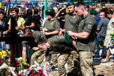 Lviv, Ukrayna, 29 Ağustos 2024 Mars meydanında, bir askeri mezarlık, askerler, silah arkadaşları, Rus ordusuna karşı savaşta ölen kendilerinden birinin mezarının önünde toplandı..