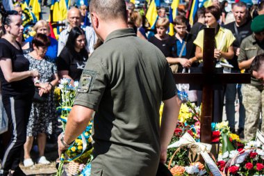 Lviv, Ukrayna, 29 Ağustos 2024 Mars meydanında, bir askeri mezarlık, askerler, silah arkadaşları, Rus ordusuna karşı savaşta ölen kendilerinden birinin mezarının önünde toplandı..