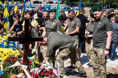 Lviv, Ukrayna, 29 Ağustos 2024 Mars meydanında, bir askeri mezarlık, askerler, silah arkadaşları, Rus ordusuna karşı savaşta ölen kendilerinden birinin mezarının önünde toplandı..