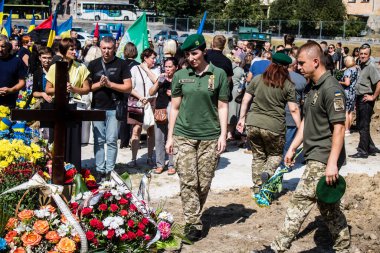 Lviv, Ukrayna, 29 Ağustos 2024 Mars meydanında, bir askeri mezarlık, askerler, silah arkadaşları, Rus ordusuna karşı savaşta ölen kendilerinden birinin mezarının önünde toplandı..