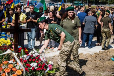 Lviv, Ukrayna, 29 Ağustos 2024 Mars meydanında, bir askeri mezarlık, askerler, silah arkadaşları, Rus ordusuna karşı savaşta ölen kendilerinden birinin mezarının önünde toplandı..