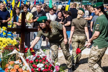Lviv, Ukrayna, 29 Ağustos 2024 Mars meydanında, bir askeri mezarlık, askerler, silah arkadaşları, Rus ordusuna karşı savaşta ölen kendilerinden birinin mezarının önünde toplandı..
