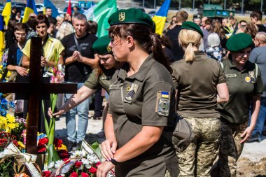 Lviv, Ukrayna, 29 Ağustos 2024 Mars meydanında, bir askeri mezarlık, askerler, silah arkadaşları, Rus ordusuna karşı savaşta ölen kendilerinden birinin mezarının önünde toplandı..