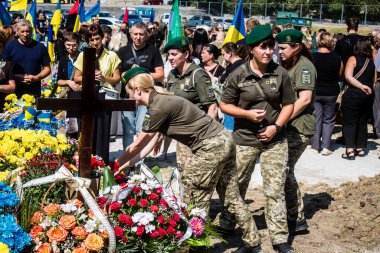 Lviv, Ukrayna, 29 Ağustos 2024 Mars meydanında, bir askeri mezarlık, askerler, silah arkadaşları, Rus ordusuna karşı savaşta ölen kendilerinden birinin mezarının önünde toplandı..