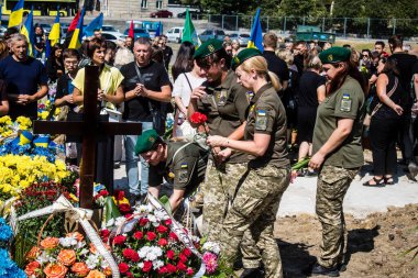 Lviv, Ukrayna, 29 Ağustos 2024 Mars meydanında, bir askeri mezarlık, askerler, silah arkadaşları, Rus ordusuna karşı savaşta ölen kendilerinden birinin mezarının önünde toplandı..