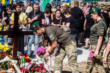 Lviv, Ukrayna, 29 Ağustos 2024 Mars meydanında, bir askeri mezarlık, askerler, silah arkadaşları, Rus ordusuna karşı savaşta ölen kendilerinden birinin mezarının önünde toplandı..